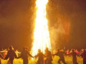 Menschen tanzen um ein Feuer und feiern traditionelle Jahreskreisfeste mit einem Ritual